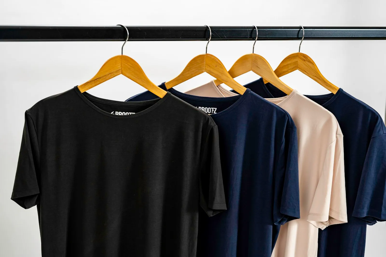 Plain T-shirts in several colours hanging on a clothing rail