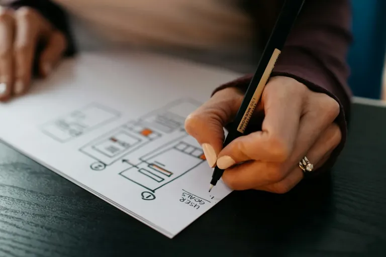 Hand sketching website wireframes on paper